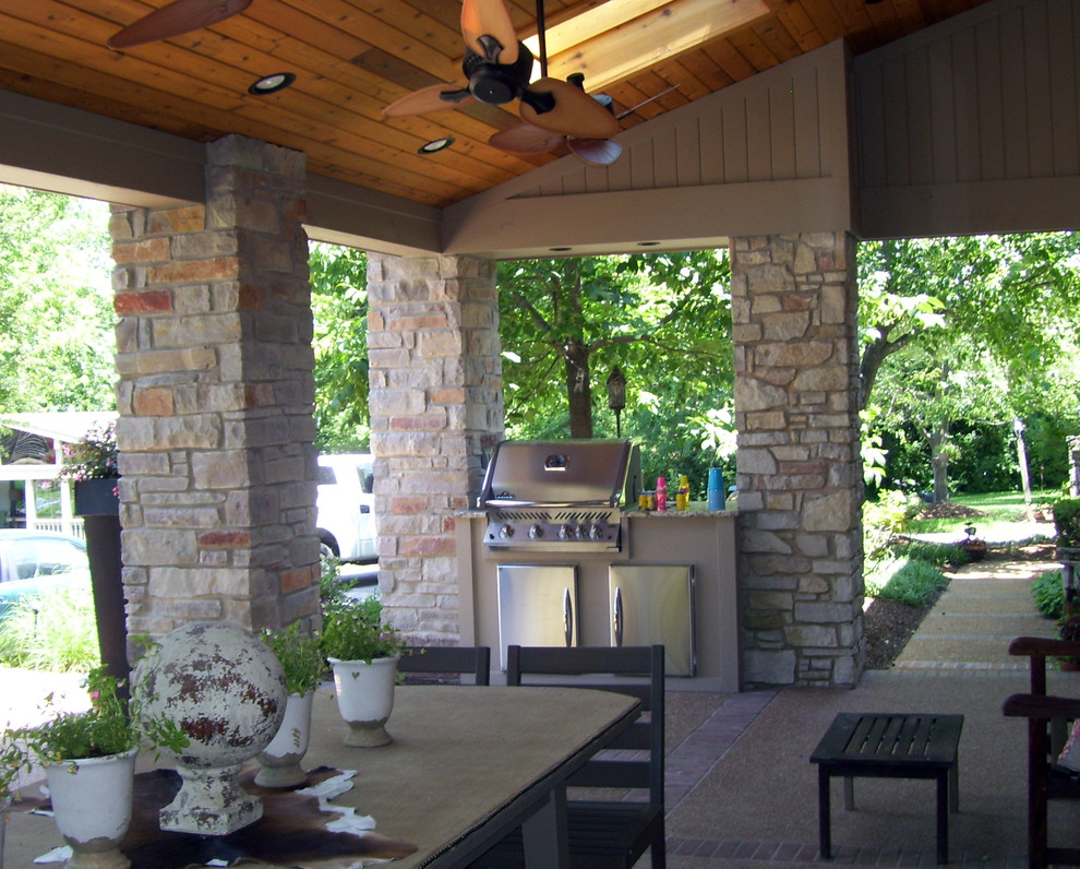 Traditional side yard patio in St Louis with an outdoor kitchen, stamped concrete and a roof extension.