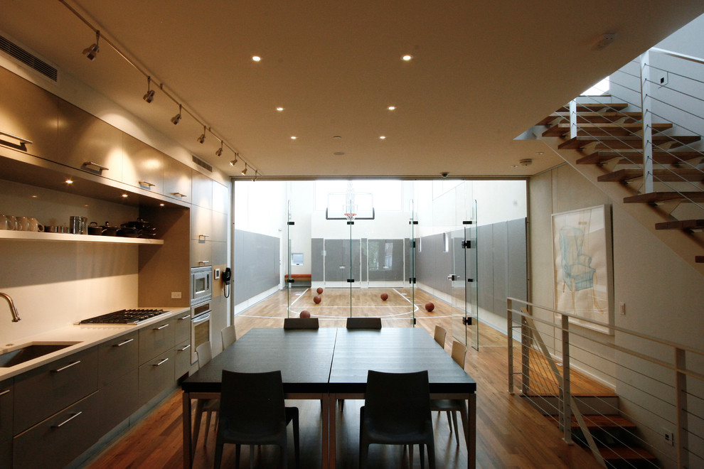 Photo of a mid-sized contemporary single-wall eat-in kitchen in Chicago with an undermount sink, flat-panel cabinets, grey cabinets, quartz benchtops, white splashback, stone slab splashback, stainless steel appliances, medium hardwood floors and no island.