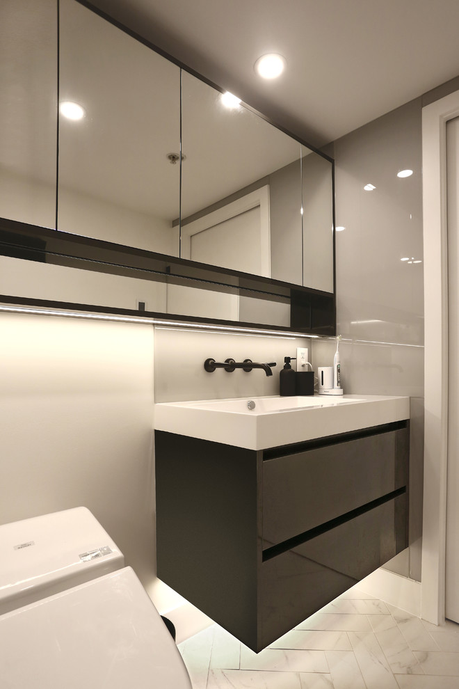 This is an example of a small contemporary 3/4 bathroom in Vancouver with flat-panel cabinets, black cabinets, a one-piece toilet, gray tile, glass tile, grey walls, ceramic floors, a vessel sink, engineered quartz benchtops and multi-coloured floor.