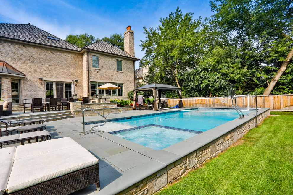 Esempio di una piscina monocorsia tradizionale rettangolare di medie dimensioni e dietro casa con pavimentazioni in pietra naturale