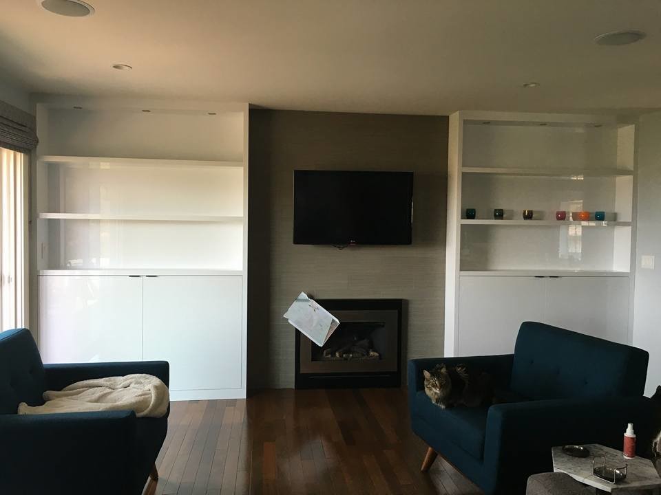This is an example of a small modern open concept family room in San Francisco with grey walls, medium hardwood floors, a standard fireplace, a tile fireplace surround and a wall-mounted tv.