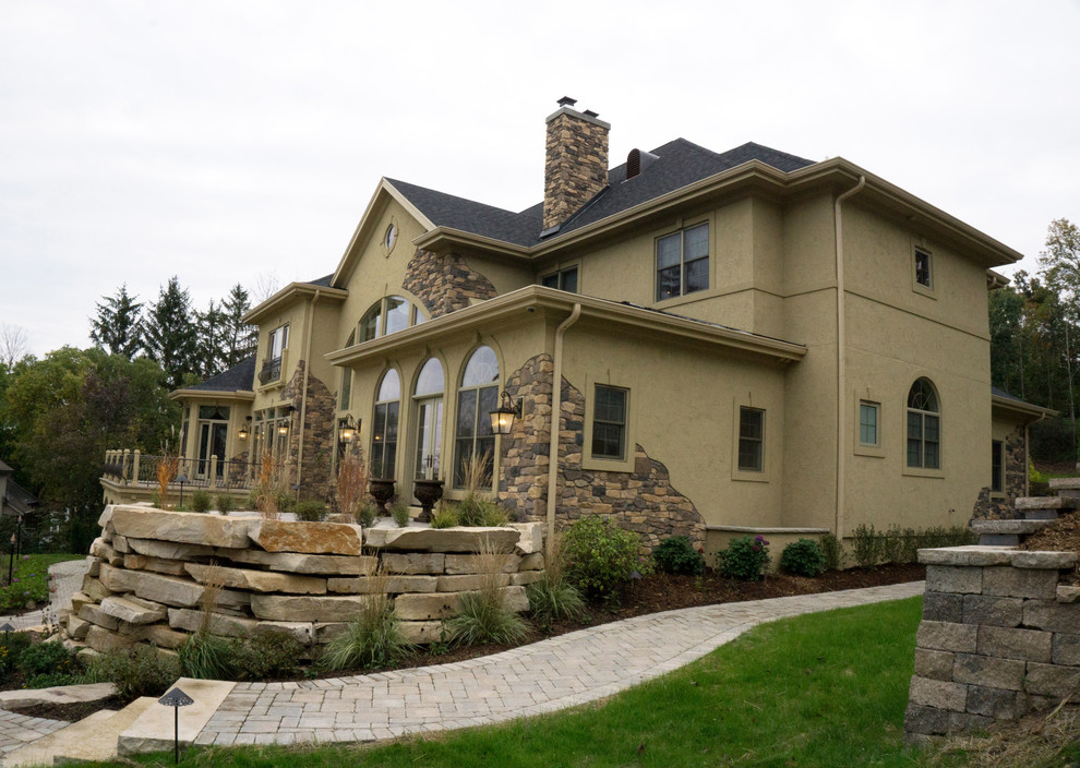 Inspiration for an expansive traditional three-storey stucco beige exterior in Milwaukee with a hip roof.