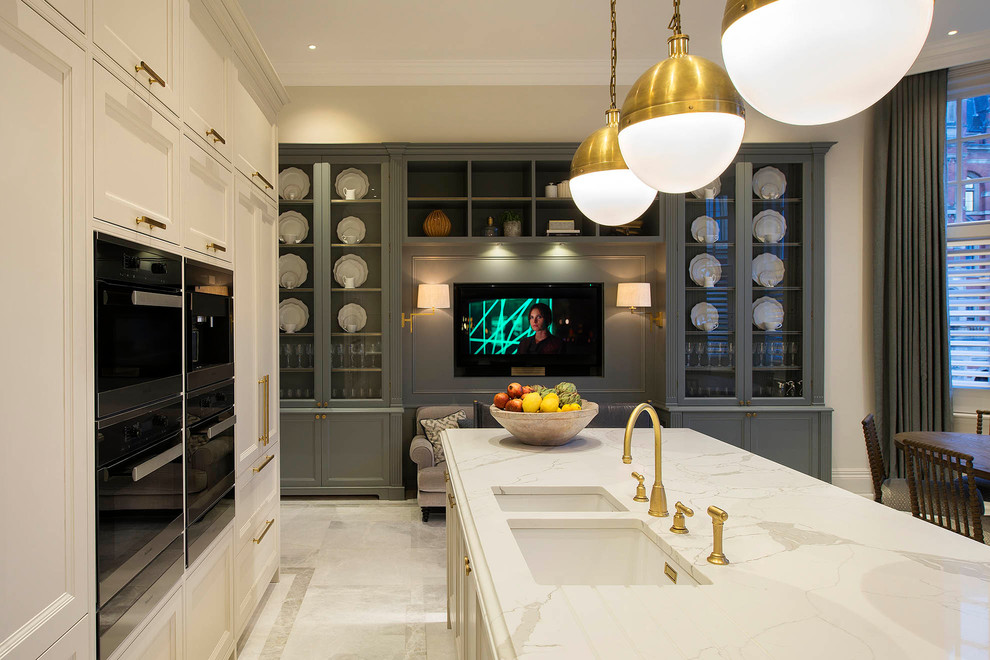 This is an example of a traditional kitchen in London with recessed-panel cabinets, white cabinets, marble benchtops, marble floors, with island and multi-coloured benchtop.