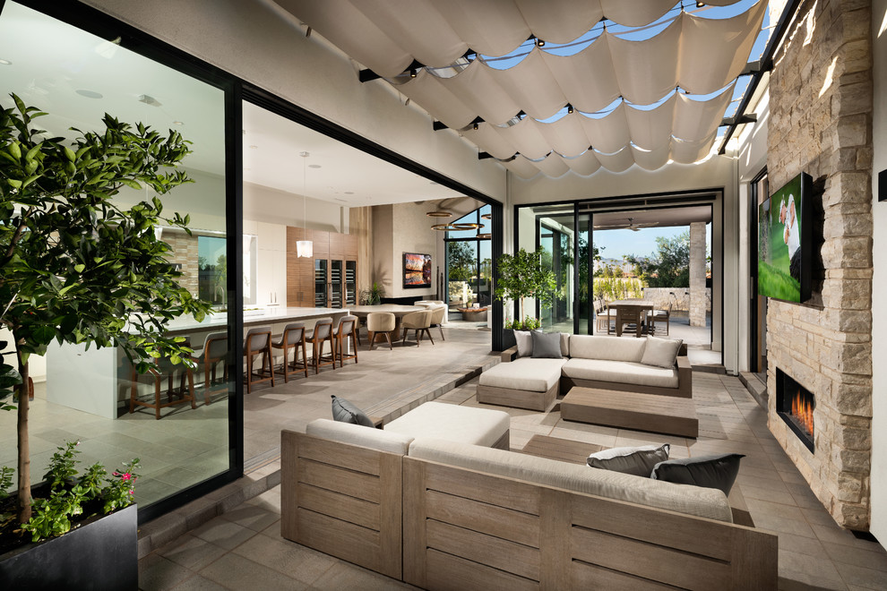This is an example of a contemporary verandah in Phoenix with with fireplace and an awning.