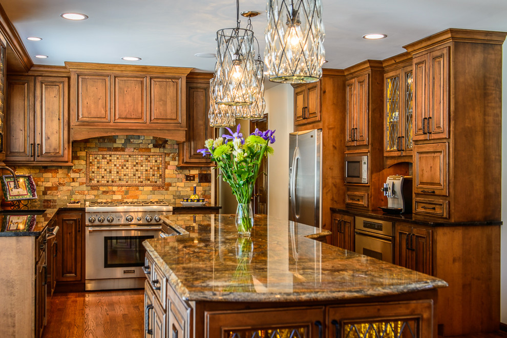 Inspiration for a large rustic kitchen remodel in Chicago with an undermount sink, raised-panel cabinets, granite countertops, stone tile backsplash, stainless steel appliances and an island