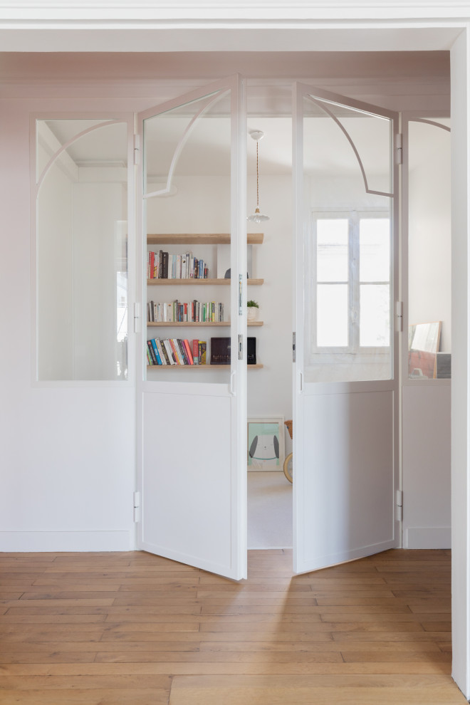 Immagine di uno studio moderno di medie dimensioni con libreria, pareti bianche, pavimento in legno massello medio, nessun camino, scrivania autoportante e pavimento marrone
