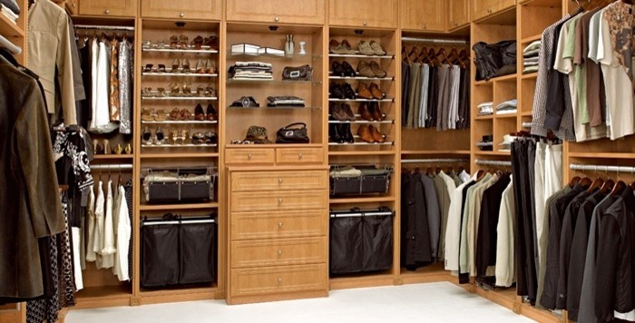 This is an example of a large transitional gender-neutral walk-in wardrobe in Cleveland with light wood cabinets, shaker cabinets, carpet and beige floor.