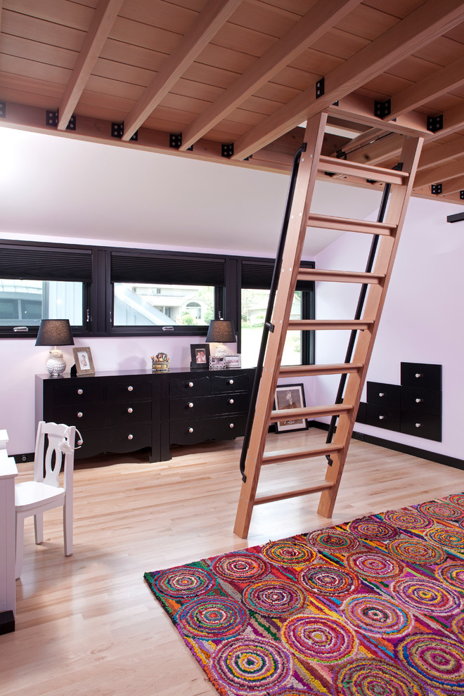 This is an example of a small contemporary loft-style bedroom in Minneapolis with pink walls and light hardwood floors.
