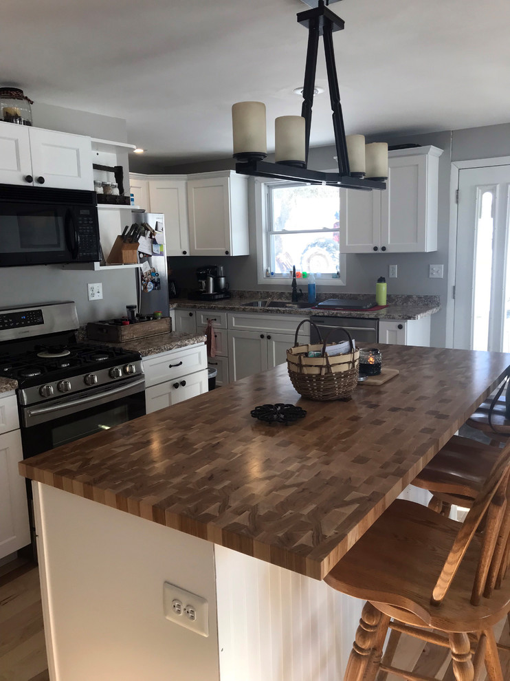 Eat-in kitchen - mid-sized transitional eat-in kitchen idea with a double-bowl sink, recessed-panel cabinets, white cabinets, laminate countertops, stainless steel appliances, an island and beige countertops