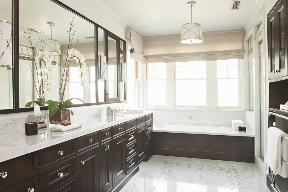 Inspiration for a traditional bathroom in Los Angeles with recessed-panel cabinets, dark wood cabinets and an alcove tub.