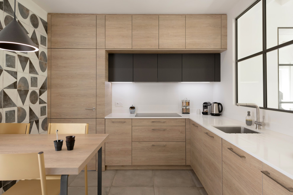 Inspiration for a mid-sized contemporary l-shaped eat-in kitchen in Lyon with an undermount sink, flat-panel cabinets, beige cabinets, white splashback, stainless steel appliances, no island, grey floor and white benchtop.