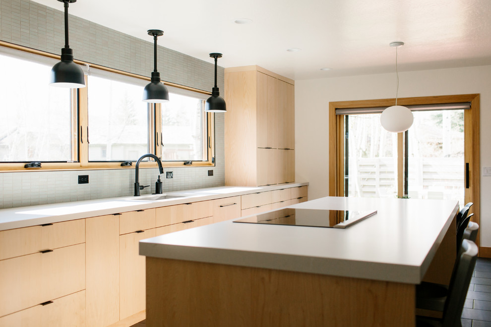 Large contemporary l-shaped separate kitchen in Seattle with an undermount sink, flat-panel cabinets, light wood cabinets, solid surface benchtops, grey splashback, porcelain splashback, stainless steel appliances, ceramic floors, with island, black floor and white benchtop.