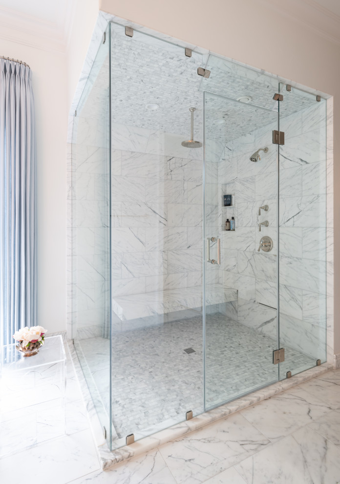 Photo of a large traditional master bathroom in Dallas with white tile, marble, white walls, marble floors, white floor, a hinged shower door and a shower seat.