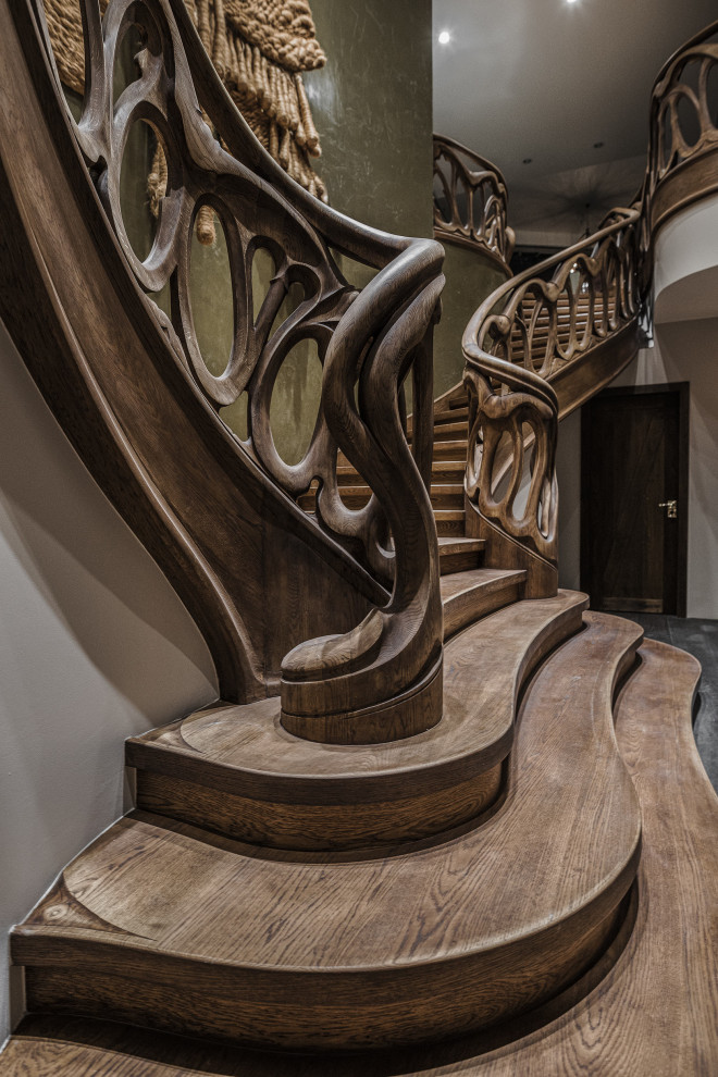 Идея дизайна: огромная изогнутая лестница в стиле фьюжн с крашенными деревянными ступенями, крашенными деревянными подступенками и деревянными перилами