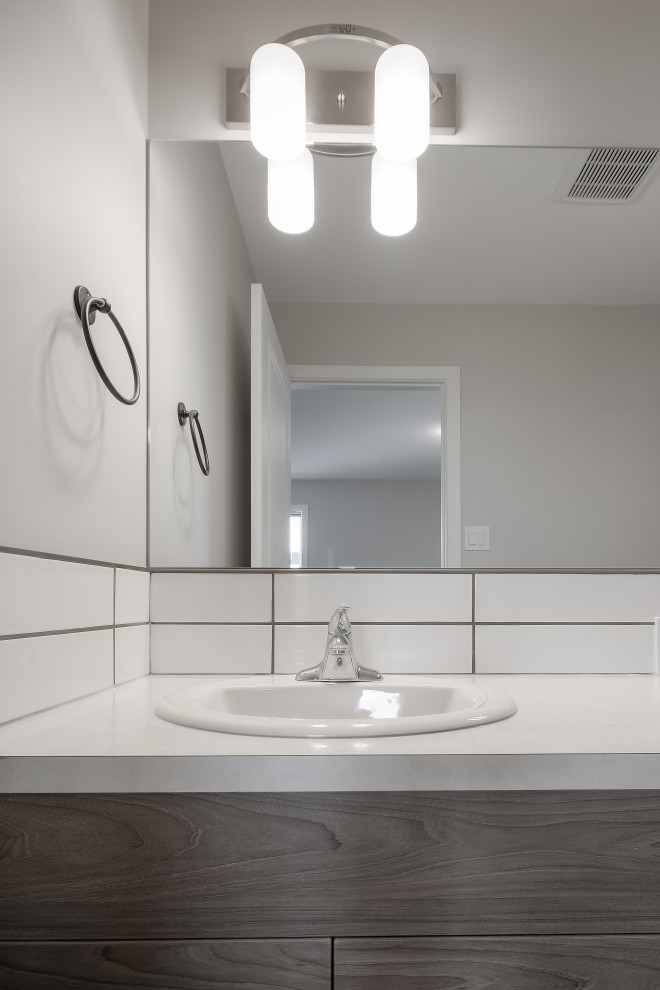 Design ideas for a contemporary master bathroom in Calgary with flat-panel cabinets, grey cabinets, an alcove shower, a two-piece toilet, white tile, subway tile, white walls, vinyl floors, a drop-in sink, laminate benchtops, grey floor, a sliding shower screen, white benchtops, a double vanity and a built-in vanity.