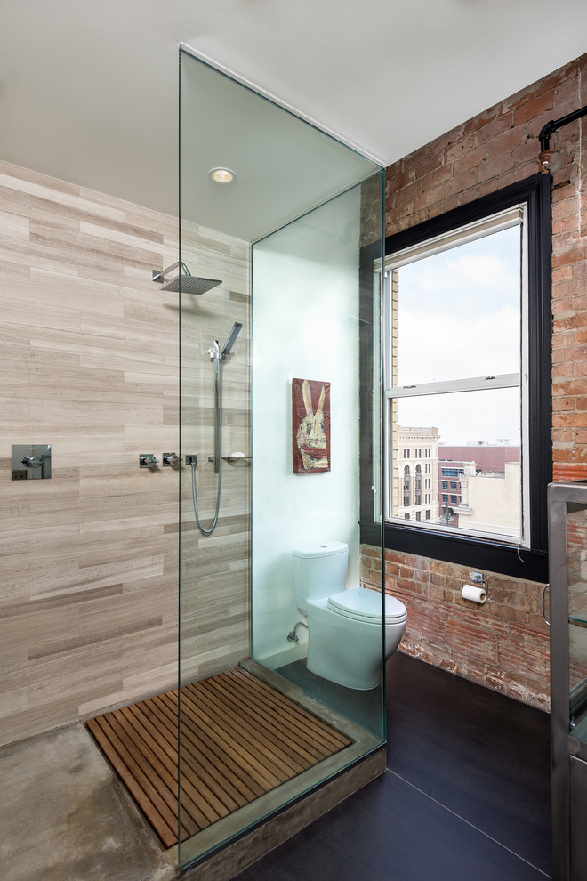 This is an example of an industrial bathroom in Houston with a one-piece toilet, an open shower, beige tile, stone tile, white walls and an open shower.