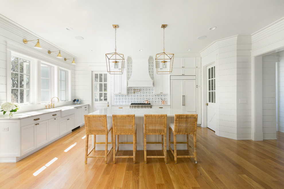 Inspiration for a large country l-shaped eat-in kitchen in Charleston with a farmhouse sink, white cabinets, panelled appliances, with island, white benchtop, brown floor, medium hardwood floors, recessed-panel cabinets, marble benchtops, multi-coloured splashback and ceramic splashback.