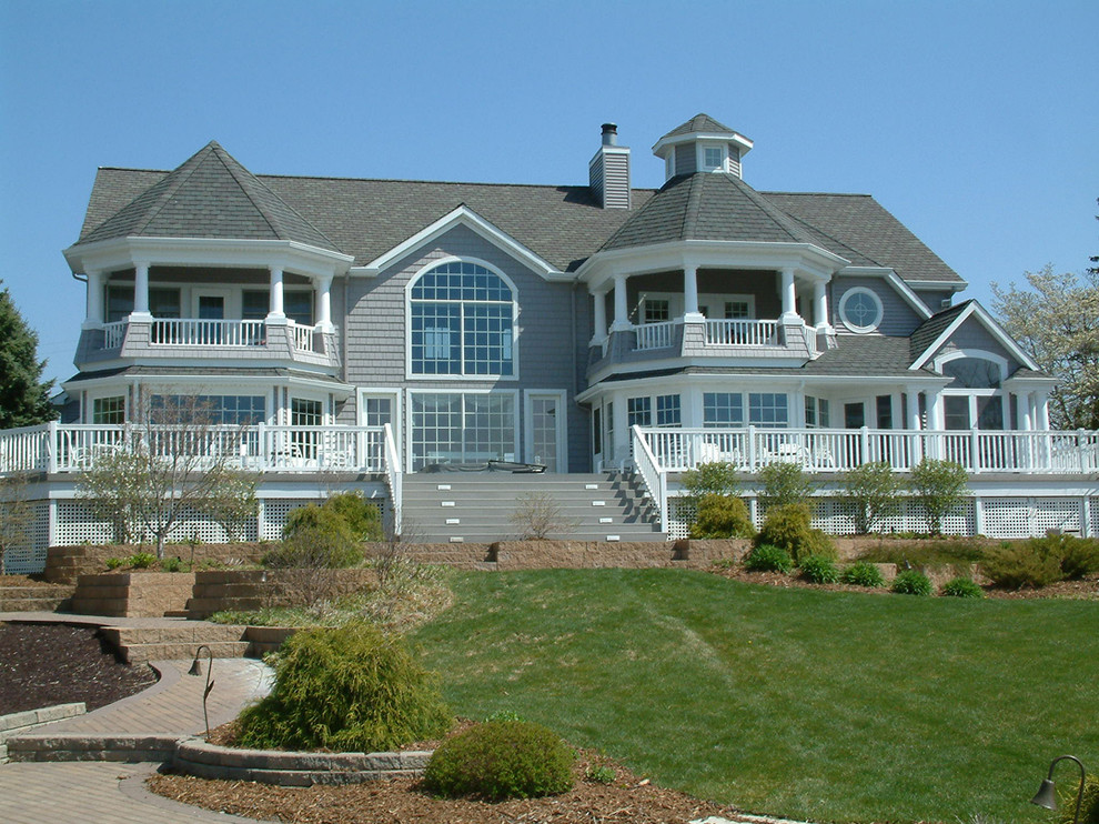 Photo of a large beach style two-storey grey exterior in Chicago with vinyl siding.