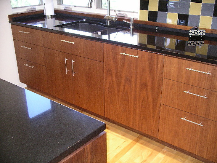 Design ideas for a mid-sized modern galley eat-in kitchen in Denver with an undermount sink, flat-panel cabinets, brown cabinets, onyx benchtops, multi-coloured splashback, ceramic splashback, black appliances, light hardwood floors, with island and brown floor.