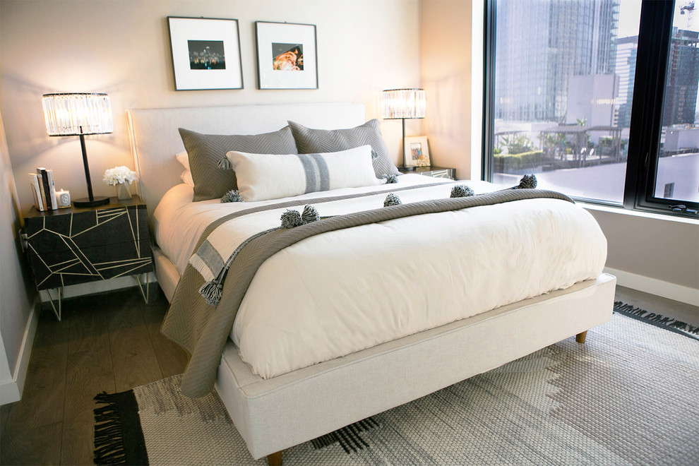 This is an example of a mid-sized modern bedroom in Los Angeles with grey walls and dark hardwood floors.