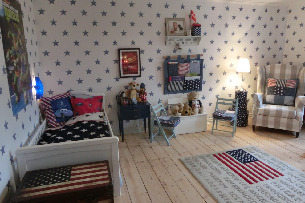 Photo of a large beach style kids' room for boys in Odense with white walls and light hardwood floors.
