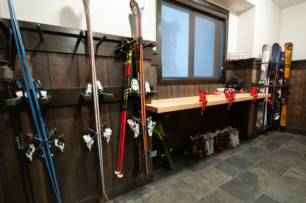 Mudroom - large rustic slate floor and multicolored floor mudroom idea with beige walls and a dark wood front door