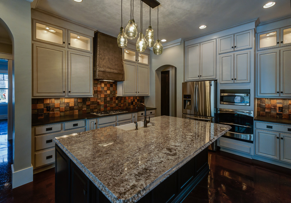 Kitchen - transitional concrete floor kitchen idea with a farmhouse sink, raised-panel cabinets, black cabinets, granite countertops and an island