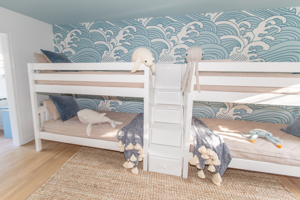 Ejemplo de dormitorio infantil de 4 a 10 años marinero grande con paredes azules, suelo de madera clara y papel pintado