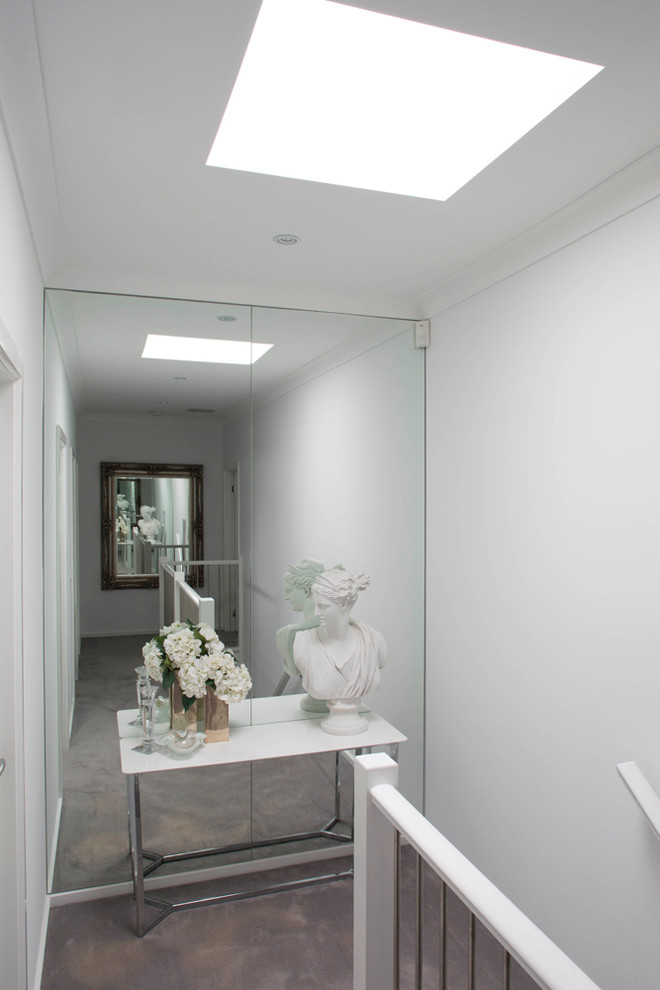 Photo of a small contemporary hallway in Melbourne with white walls, carpet and grey floor.
