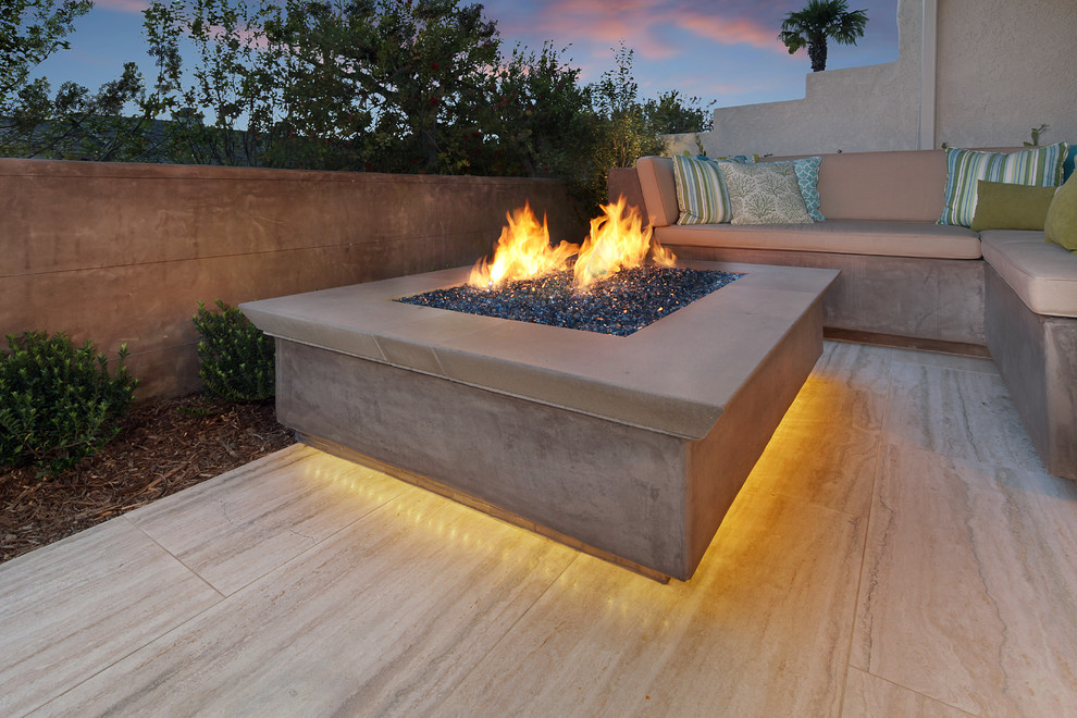 Inspiration for a mid-sized contemporary backyard patio in Orange County with a fire feature and natural stone pavers.