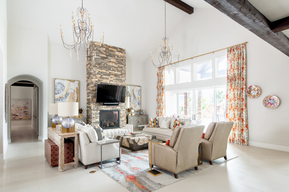 This is an example of an expansive mediterranean open plan games room in Houston with white walls, porcelain flooring, a standard fireplace, a stone fireplace surround, a wall mounted tv, white floors, a vaulted ceiling and a chimney breast.