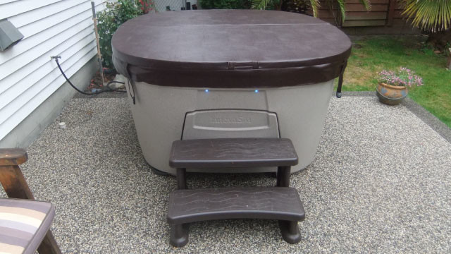 Example of a backyard gravel and round aboveground hot tub design