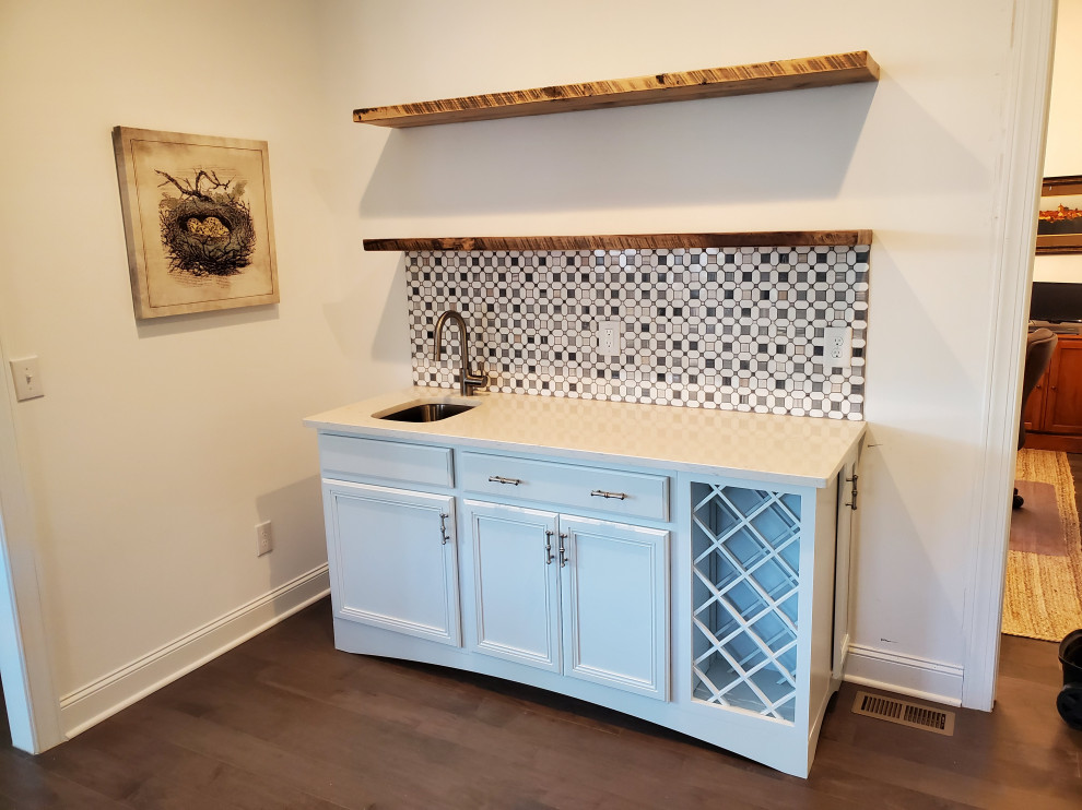 Design ideas for a small traditional galley wet bar in Raleigh with a submerged sink, flat-panel cabinets, white cabinets, quartz worktops, white splashback, mosaic tiled splashback, laminate floors, brown floors and white worktops.