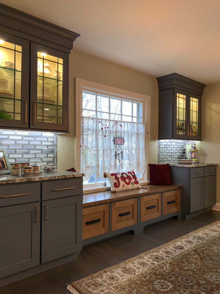 Foto på ett mellanstort lantligt kök, med skåp i shakerstil, grå skåp, granitbänkskiva, grått stänkskydd, stänkskydd i tunnelbanekakel, rostfria vitvaror, mörkt trägolv och en köksö