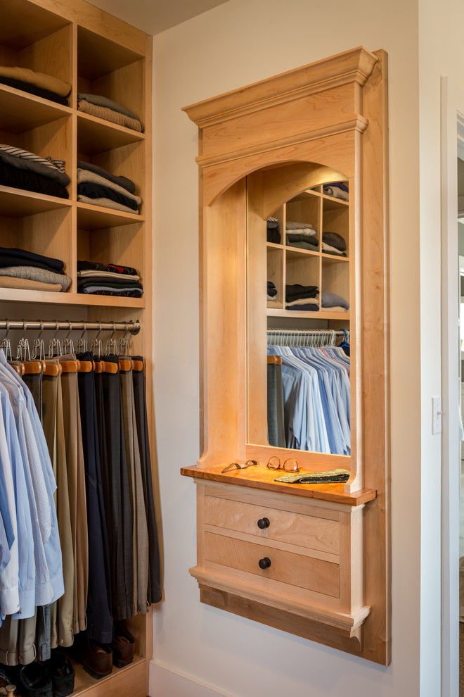 This is an example of a traditional walk-in wardrobe in Philadelphia with flat-panel cabinets, light wood cabinets and carpet.