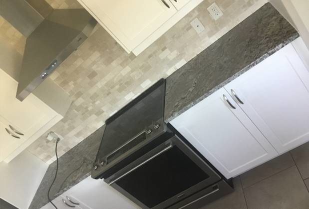 Kitchen - small transitional kitchen idea with granite countertops, stainless steel appliances and brown countertops