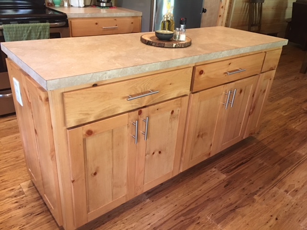 Large mountain style l-shaped medium tone wood floor and brown floor kitchen photo with a double-bowl sink, shaker cabinets, light wood cabinets, solid surface countertops, brown backsplash, wood backsplash and stainless steel appliances