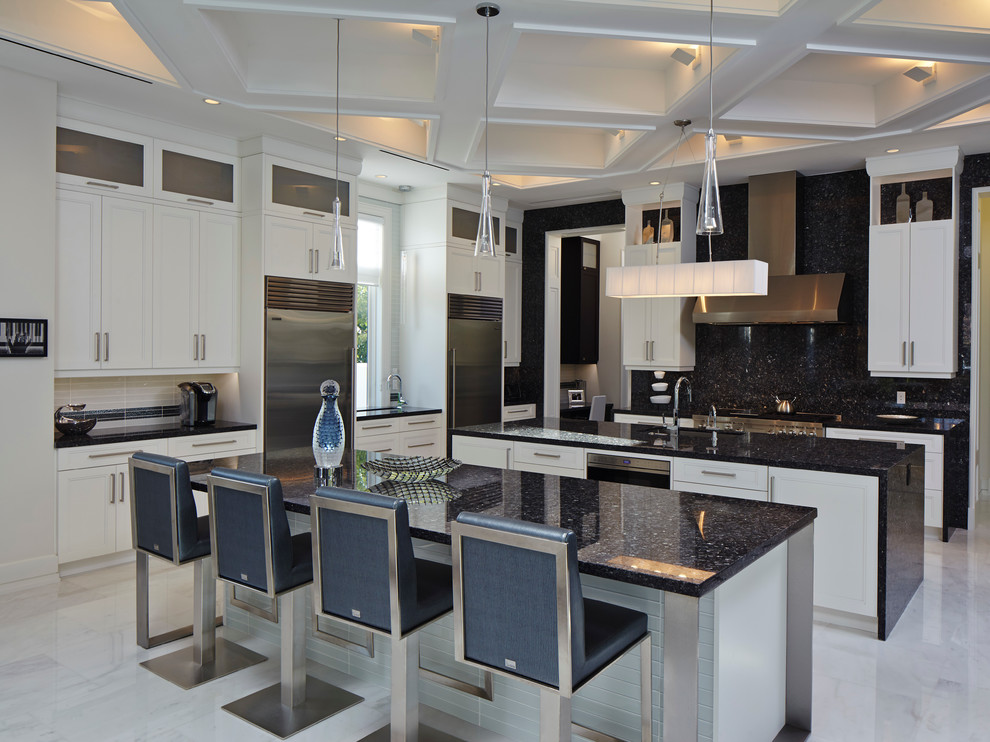 Photo of a transitional kitchen in Miami with an undermount sink, recessed-panel cabinets, black splashback, stainless steel appliances and multiple islands.