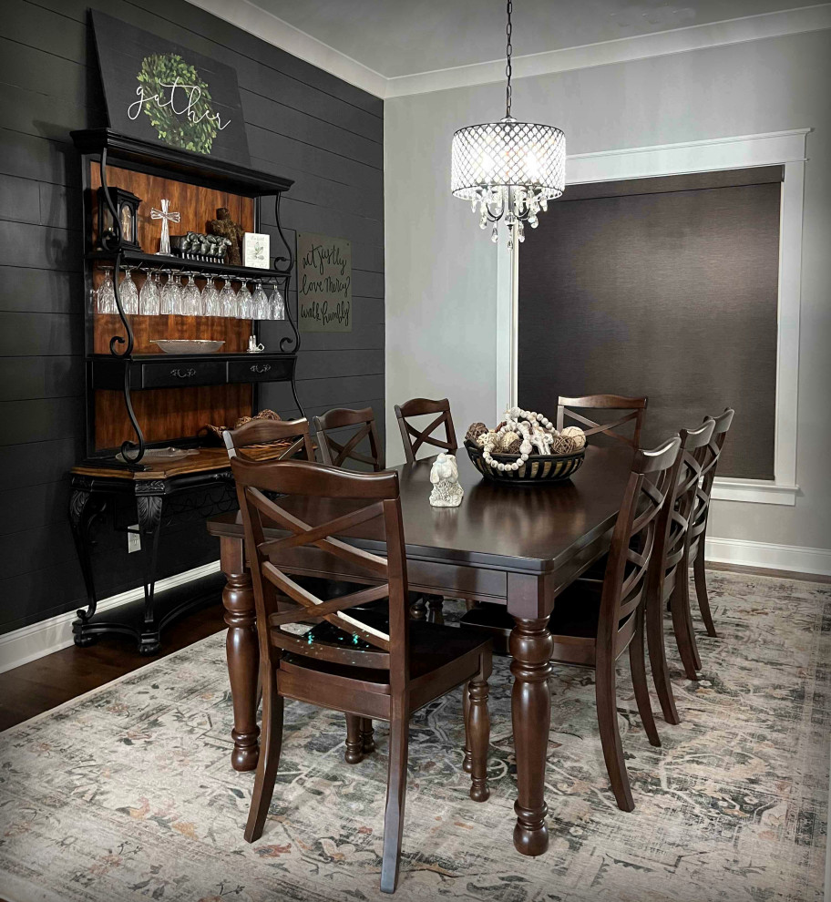 Idee per una sala da pranzo aperta verso la cucina di medie dimensioni con pareti nere, parquet scuro, pavimento marrone e pareti in perlinato