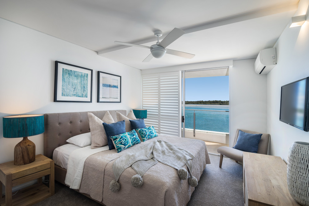 Photo of a beach style master bedroom in Sunshine Coast with white walls, carpet and grey floor.