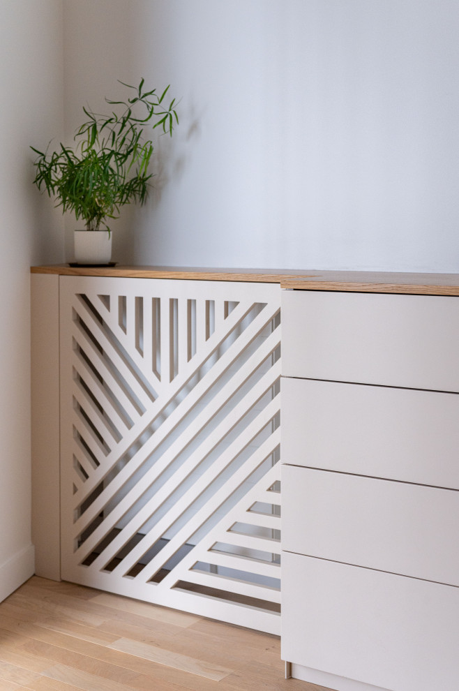 Design ideas for a small scandinavian master bedroom in Paris with beige walls, light hardwood floors and wallpaper.