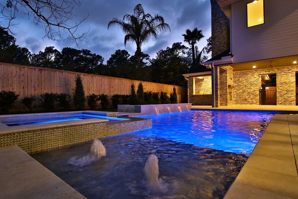 This is an example of a mid-sized transitional backyard rectangular natural pool in Houston with natural stone pavers.