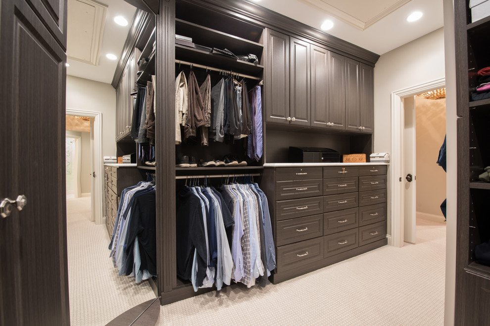 This is an example of a traditional men's storage and wardrobe in Chicago with raised-panel cabinets, grey cabinets, carpet and beige floor.