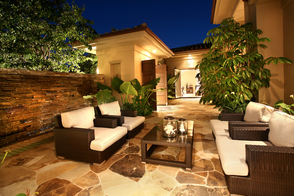 Photo of a large mediterranean backyard patio in Orange County with natural stone pavers.