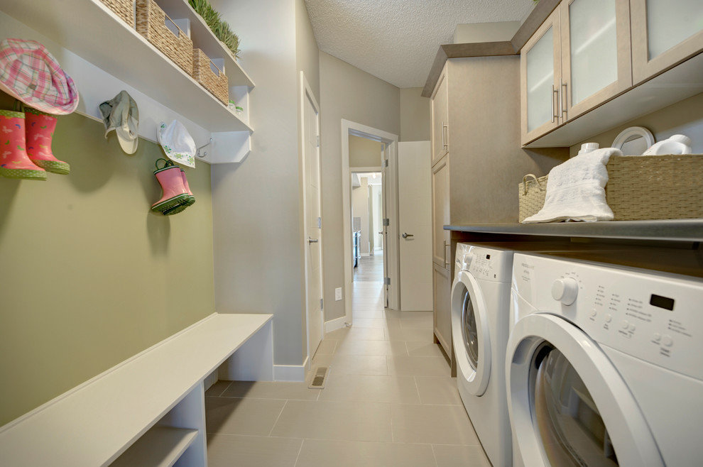 This is an example of a mid-sized transitional galley utility room in Edmonton with shaker cabinets, light wood cabinets, laminate benchtops, beige walls, ceramic floors, a side-by-side washer and dryer and beige floor.