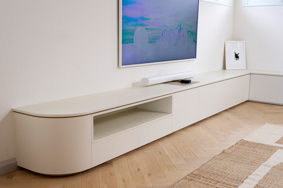 Imagen de sala de estar cerrada escandinava grande con paredes blancas, suelo de madera clara, televisor colgado en la pared, suelo marrón y bandeja