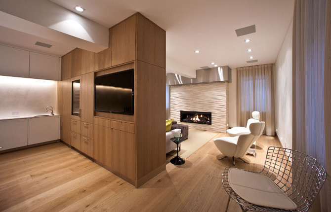 Photo of a large contemporary fully buried basement in Other with white walls, light hardwood floors, a standard fireplace, a stone fireplace surround and beige floor.