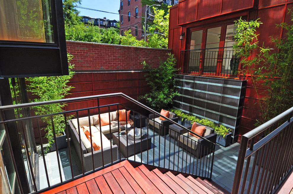 Photo of a small contemporary courtyard patio in Boston with a container garden, natural stone pavers and no cover.