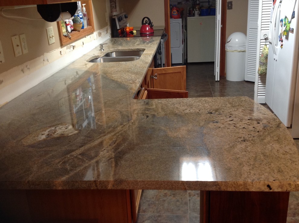 Inspiration for a l-shaped eat-in kitchen remodel with flat-panel cabinets, a peninsula, an undermount sink, brown backsplash, glass tile backsplash and stainless steel appliances