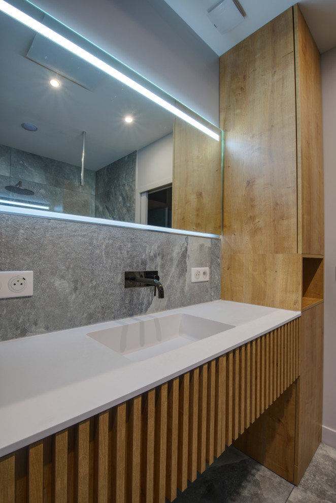 Cette photo montre une salle de bain principale tendance de taille moyenne avec une douche à l'italienne, un carrelage gris, un mur gris, un lavabo suspendu, un sol gris, une porte coulissante et meuble simple vasque.